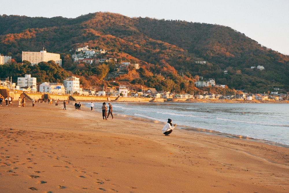 a group of people standing on top of a sandy beach