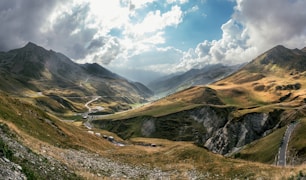 a scenic view of a valley with mountains in the background