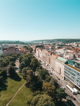A cityscape with green rooftops and eco-friendly transport vehicles in motion.