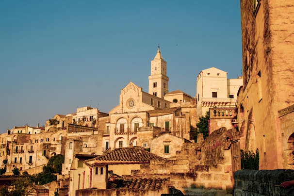 Historic stone buildings of Rohan bathed in soft afternoon light, showcasing traditional architecture.
