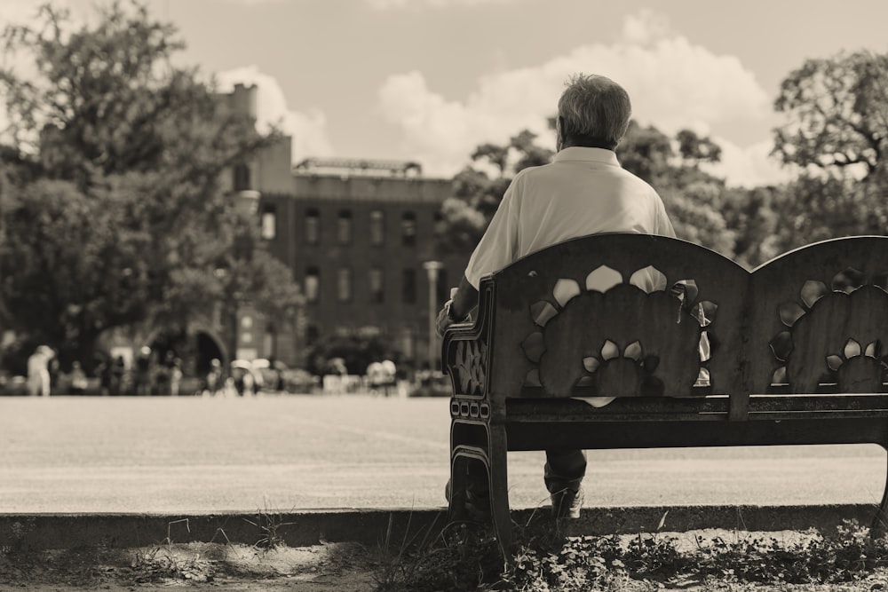 a person sitting on a bench in a park