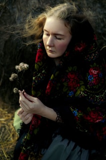 A serene woman sitting peacefully on a lavender blanket, wearing a soft gold shawl.