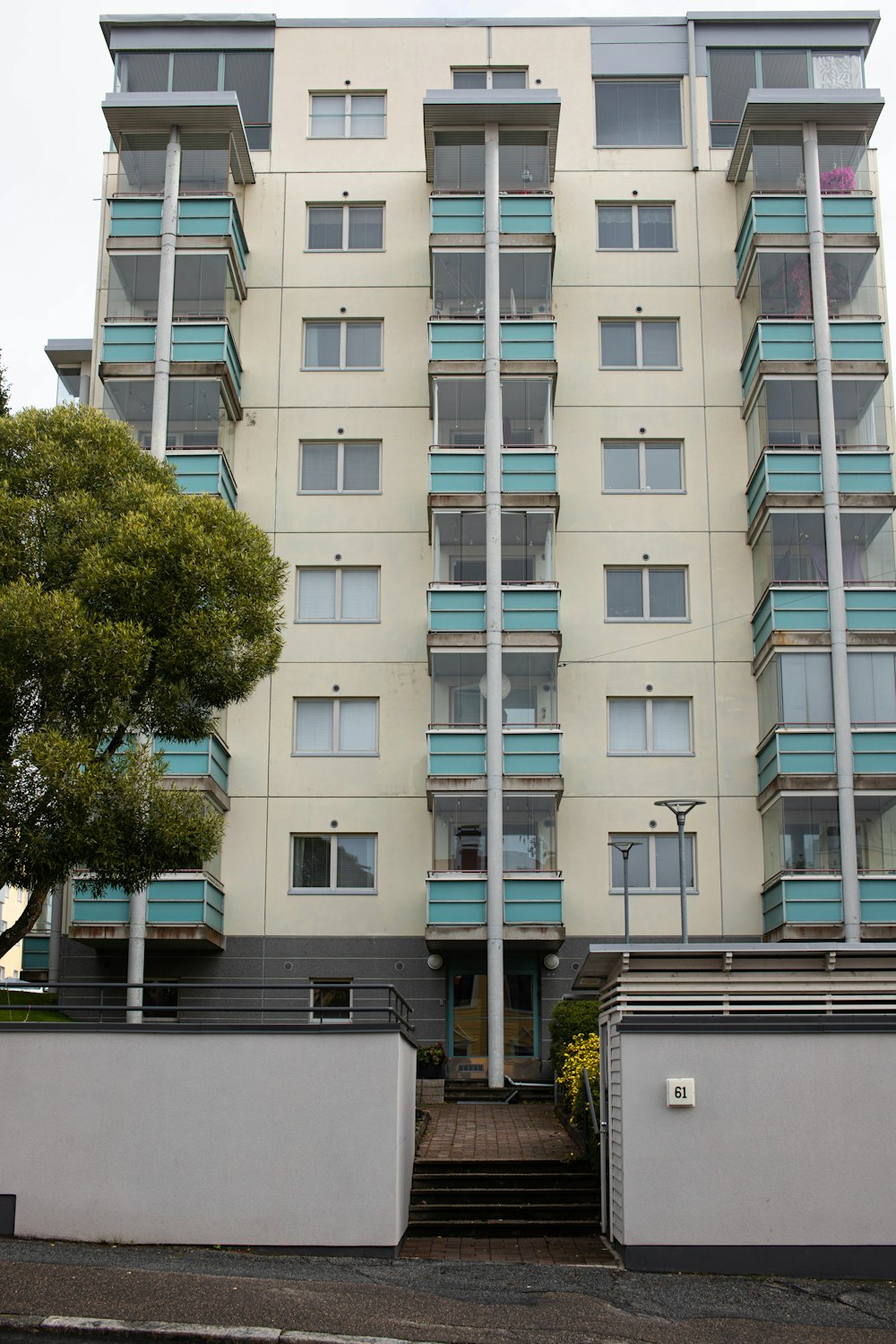 a tall white building with blue balconies