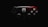 A video game controller features a distinctive design with a black and red color scheme. The left side is predominantly black, while the right side is red with intricate patterns. A prominent white spider emblem adorns the center, adding a thematic element.
