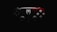 A video game controller features a distinctive design with a black and red color scheme. The left side is predominantly black, while the right side is red with intricate patterns. A prominent white spider emblem adorns the center, adding a thematic element.
