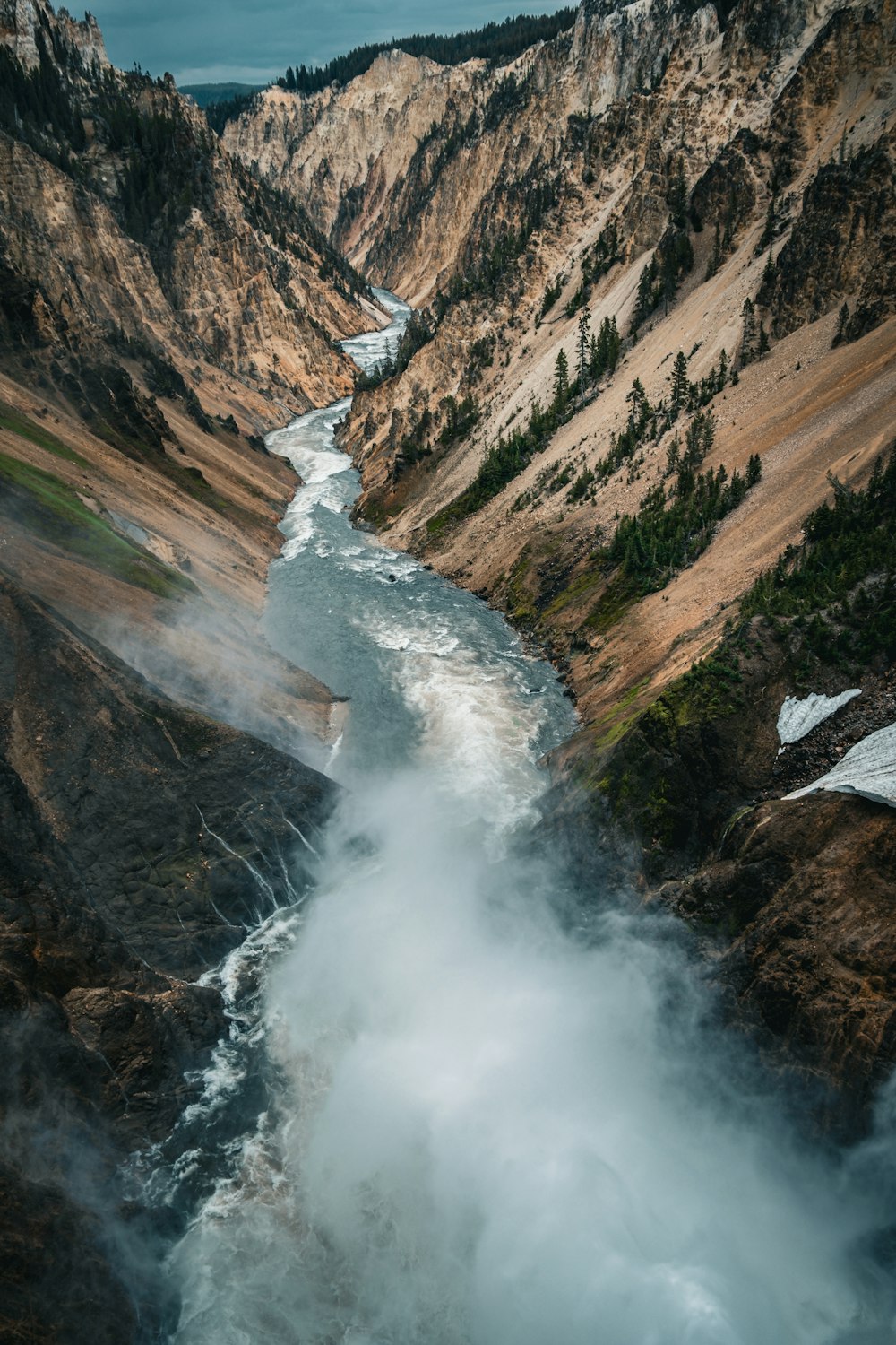 a river flowing through a valley surrounded by mountains