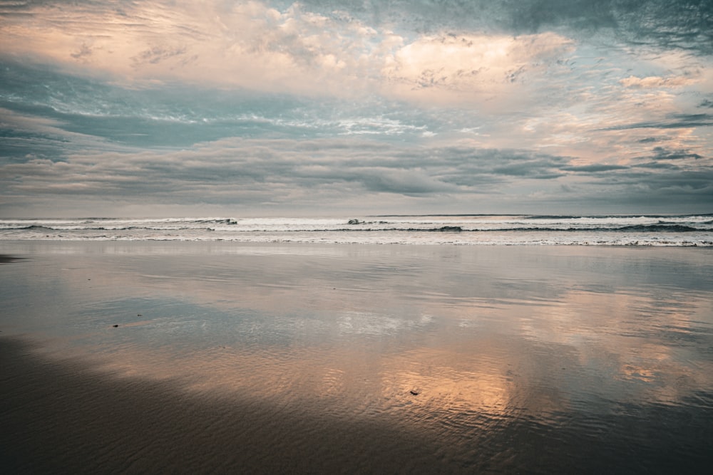 a person walking on a beach with a surfboard