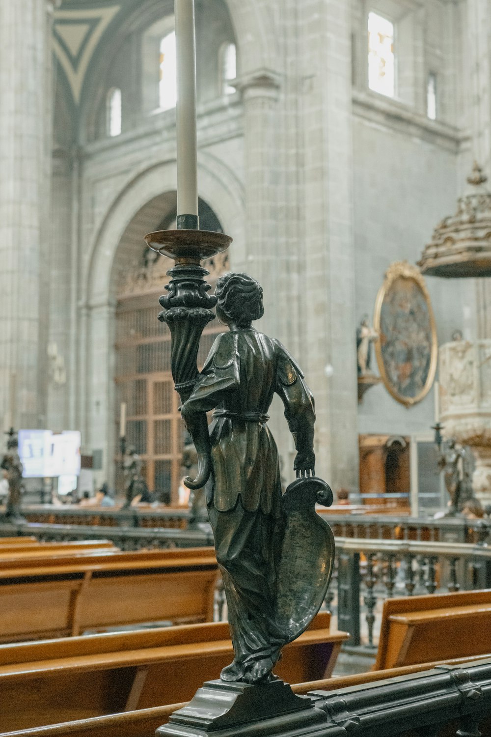 a statue of an angel holding a candle in a church