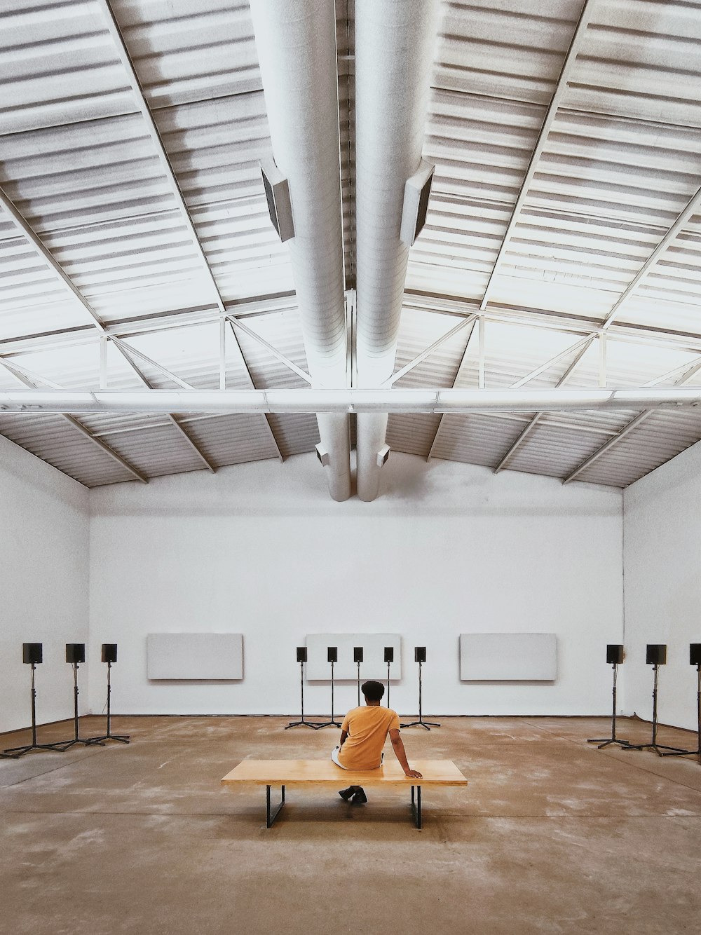 a person sitting on a bench in an empty room