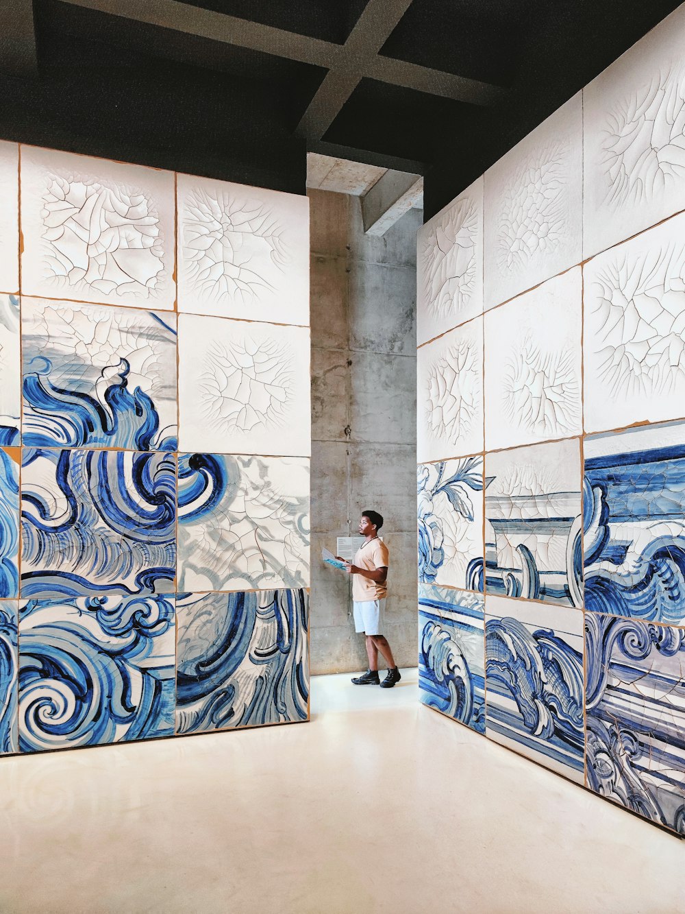 a man standing in front of a blue and white wall