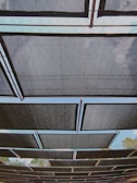 A panoramic view of iron sheets arranged in rows under bright sunlight.