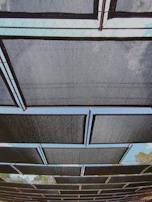 Stacked galvanized steel panels reflecting sunlight outdoors.