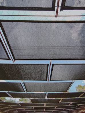 A panoramic view of iron sheets arranged in rows under bright sunlight.