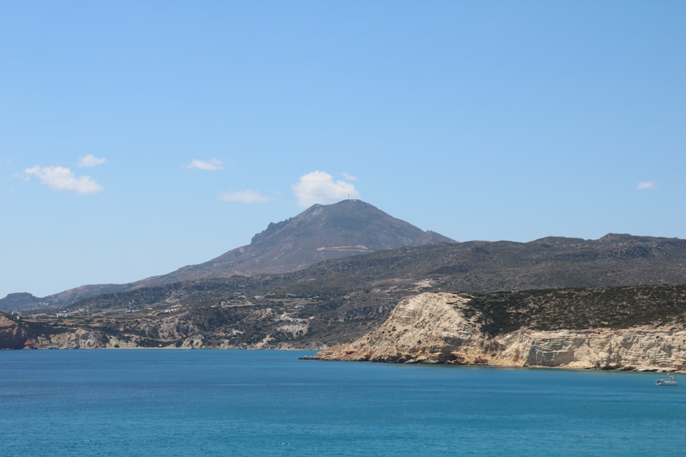 a large body of water with a mountain in the background