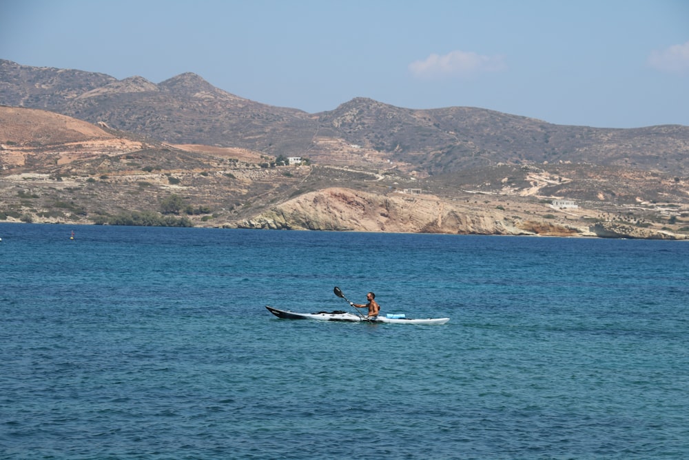 a person in a kayak in the middle of a body of water