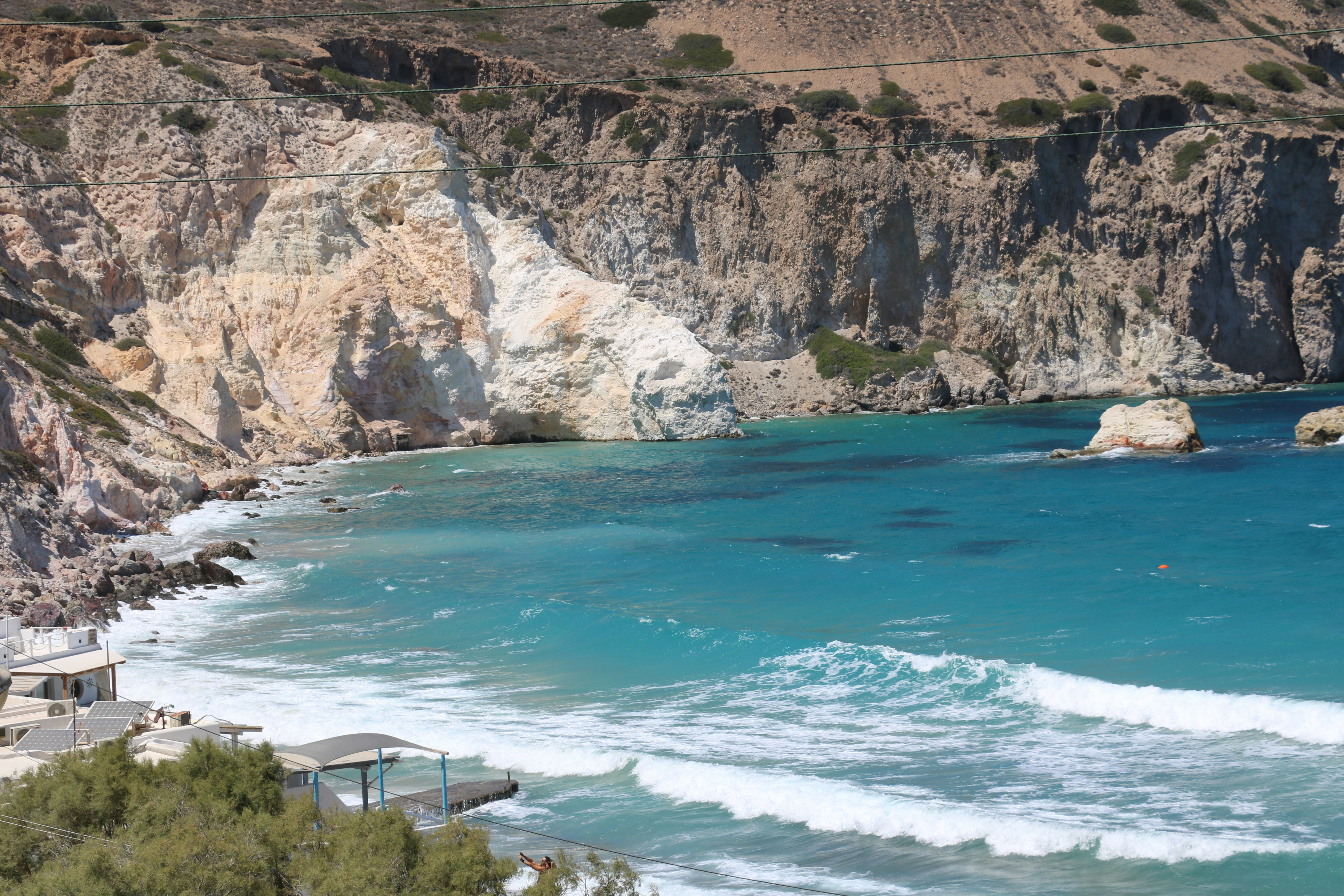 a view of a beach with a cliff in the background, Greece, Summer 2023