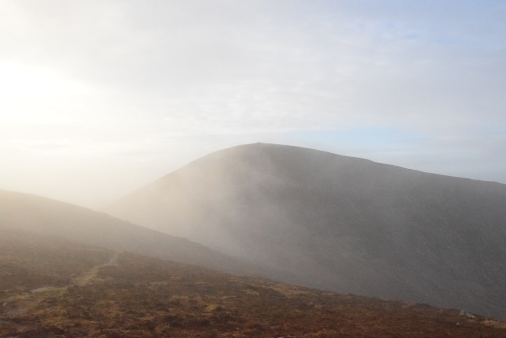 une colline couverte de brouillard et de brume par temps nuageux