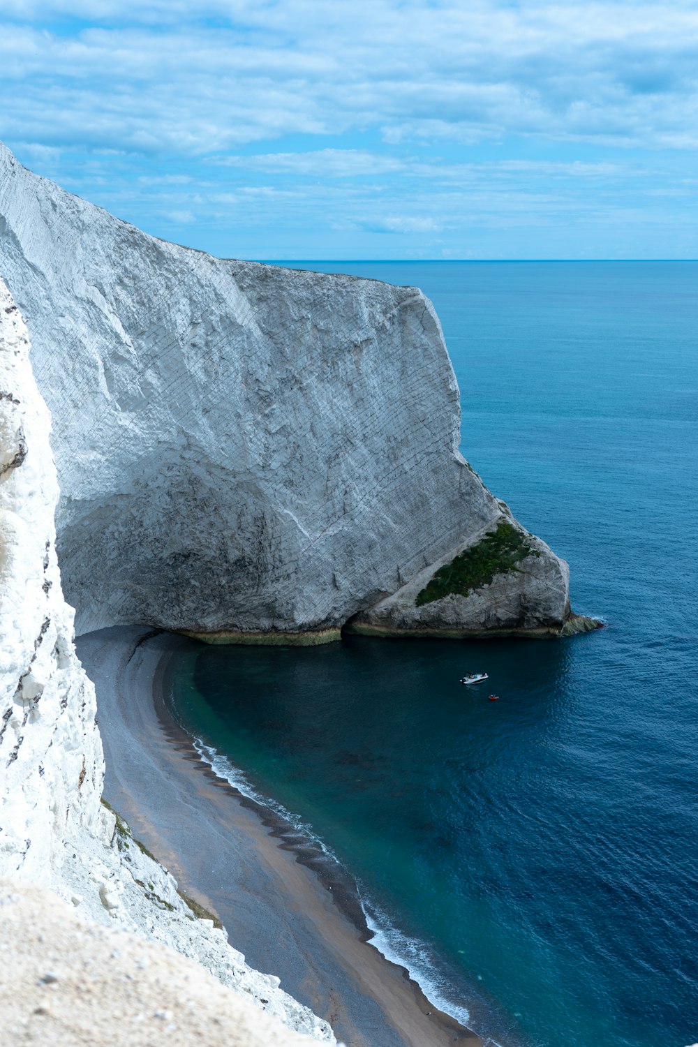 a boat is in the water near a large rock