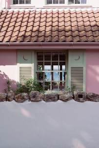 A charming seaside cottage with colorful shutters overlooking a tranquil beach.