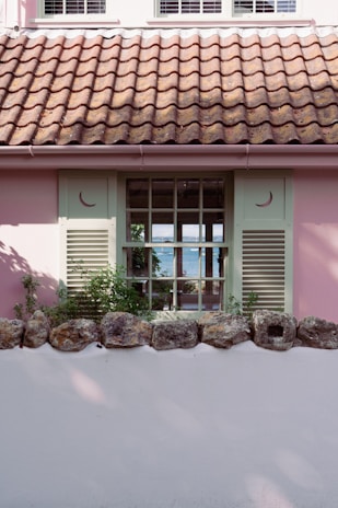 A charming seaside house with bright shutters and a view of the sparkling Mediterranean Sea.