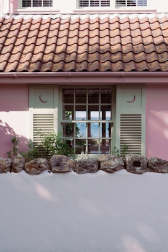 A charming seaside house with bright shutters and a view of the sparkling Mediterranean Sea.
