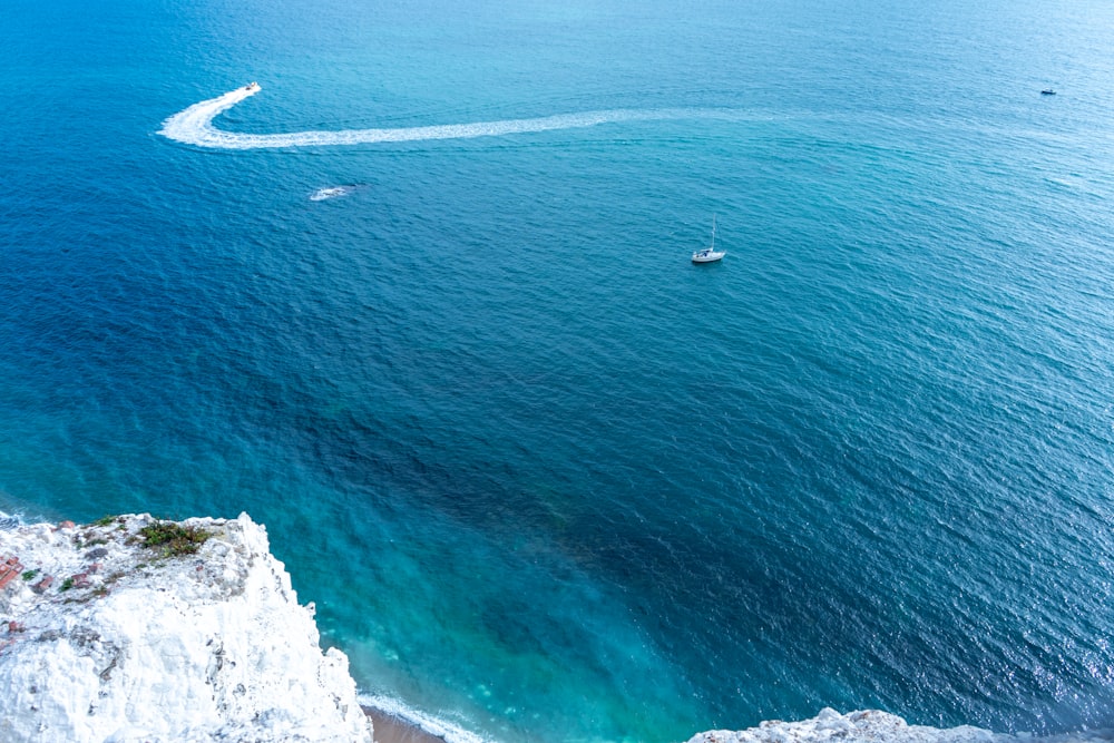 a boat is in the water near a cliff