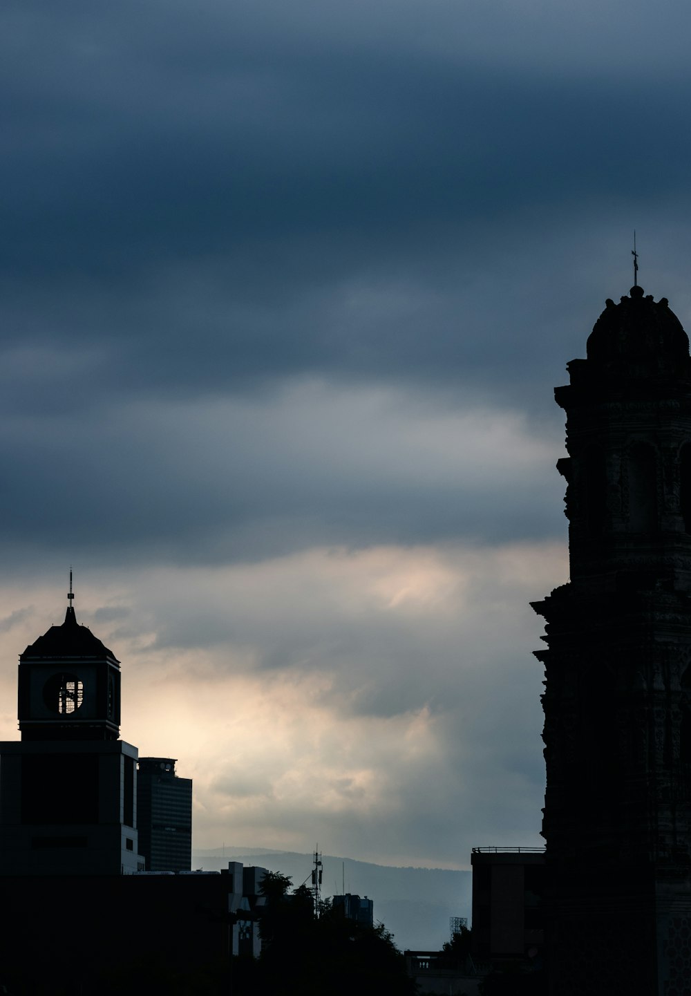 a large clock tower towering over a city under a cloudy sky
