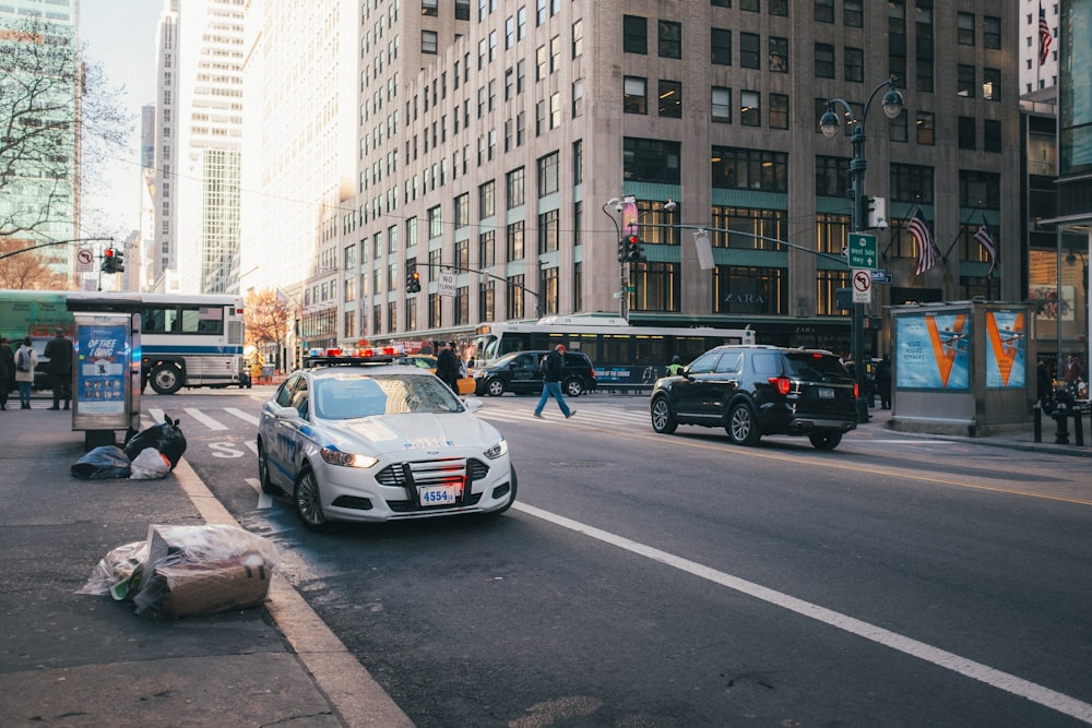 a police car driving down a street next to tall buildings