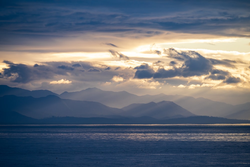 a large body of water with mountains in the background