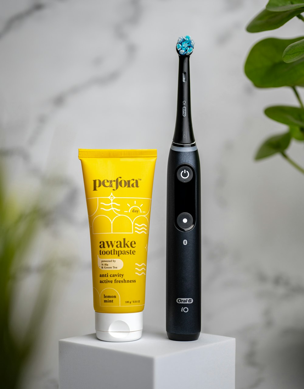 une brosse à dents électrique noire à côté d’un tube de crème solaire et d’un tube de