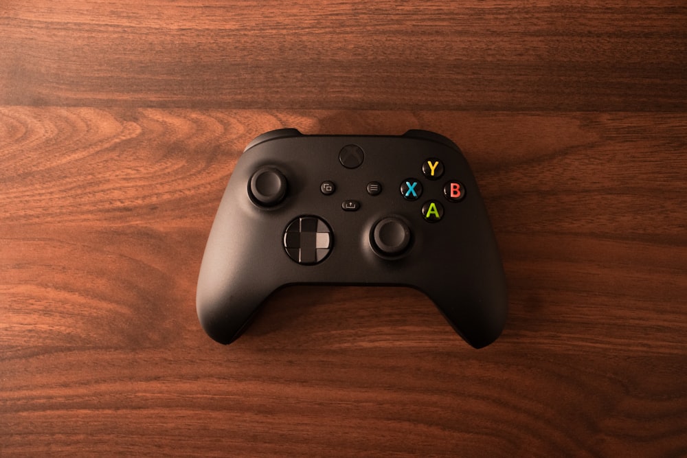 a close up of a controller on a wooden surface