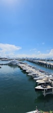 Surveyor inspecting a yacht hull closely at the marina under bright daylight.