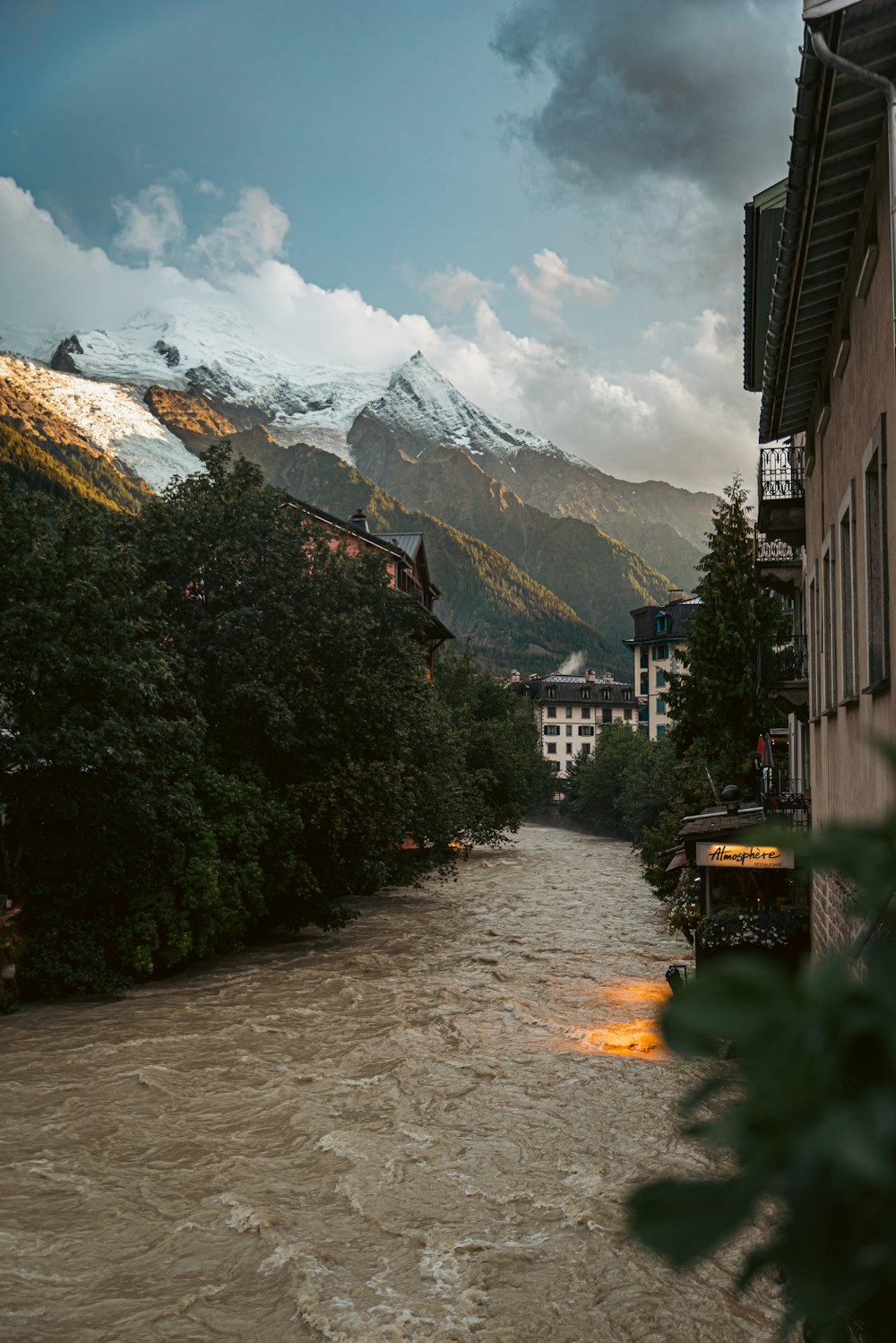 a river running through a city next to a tall building