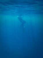 A deep scuba diver capturing the mysterious underwater landscape with a flashlight.
