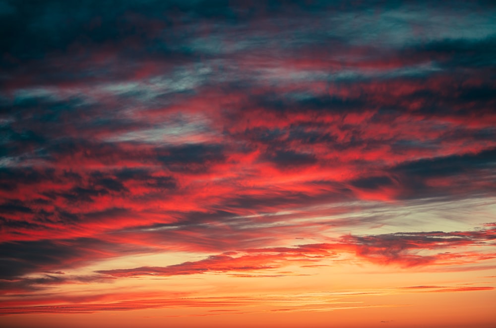 Ein roter und blauer Himmel bei Sonnenuntergang mit einem Flugzeug im Vordergrund