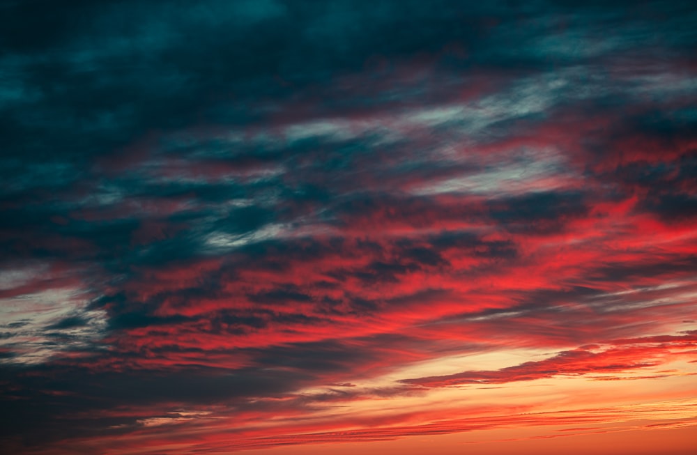 um céu vermelho e azul com algumas nuvens