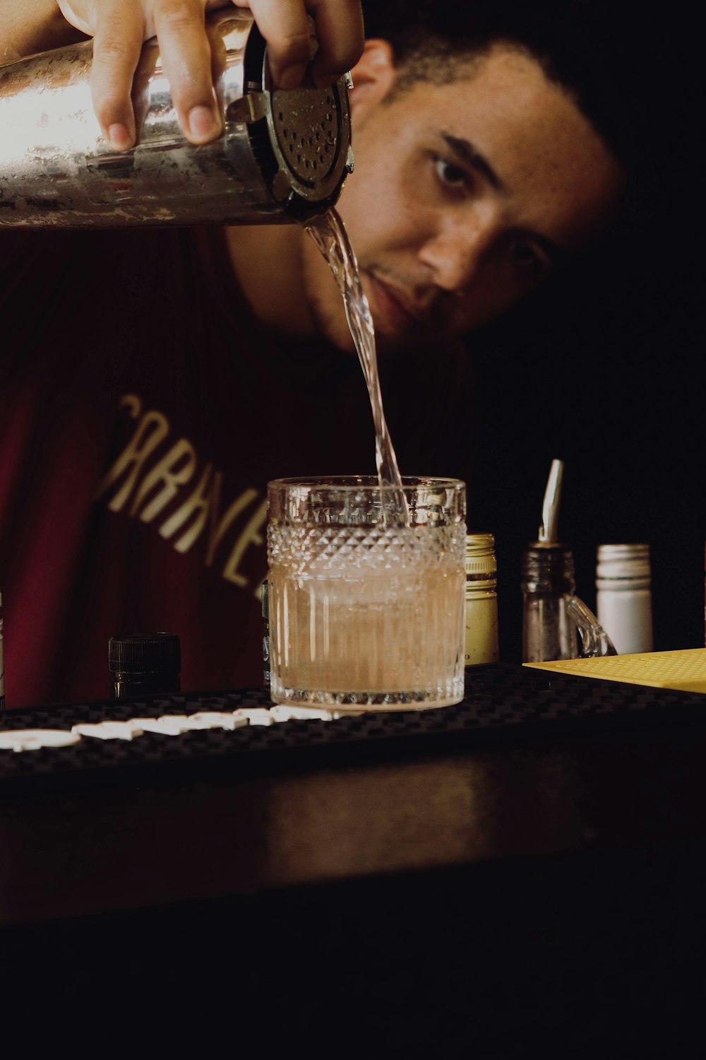 a man pouring a drink into a glass