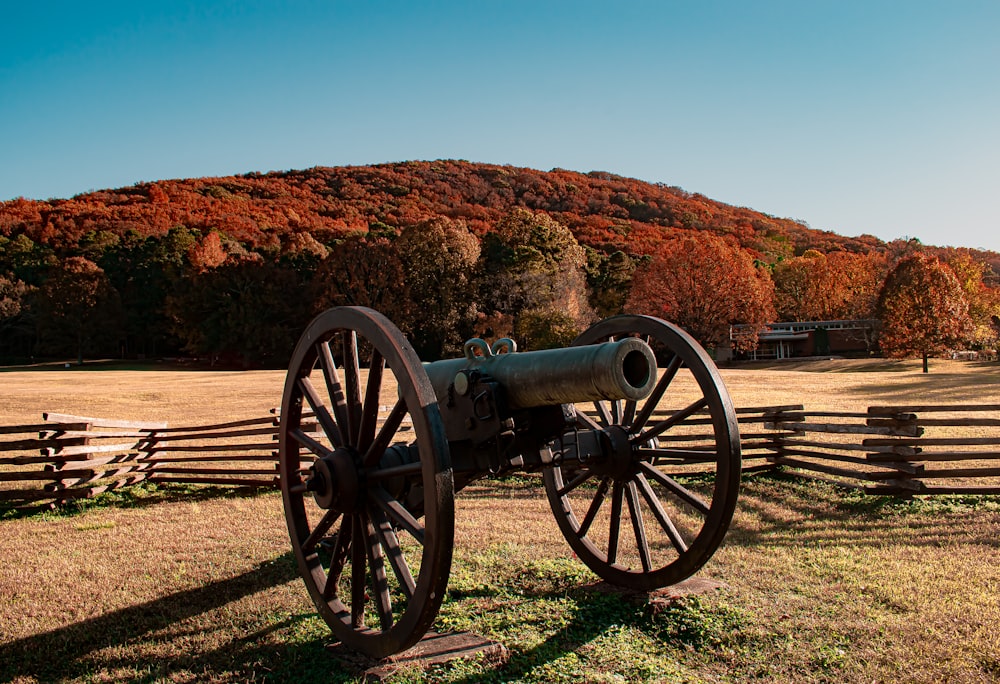 an old cannon sitting on top of a grass covered field