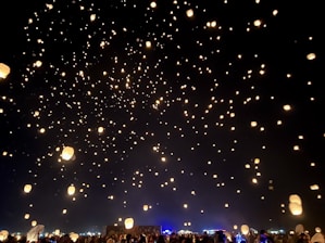 An ethereal setting with floating lanterns illuminating a peaceful gathering.