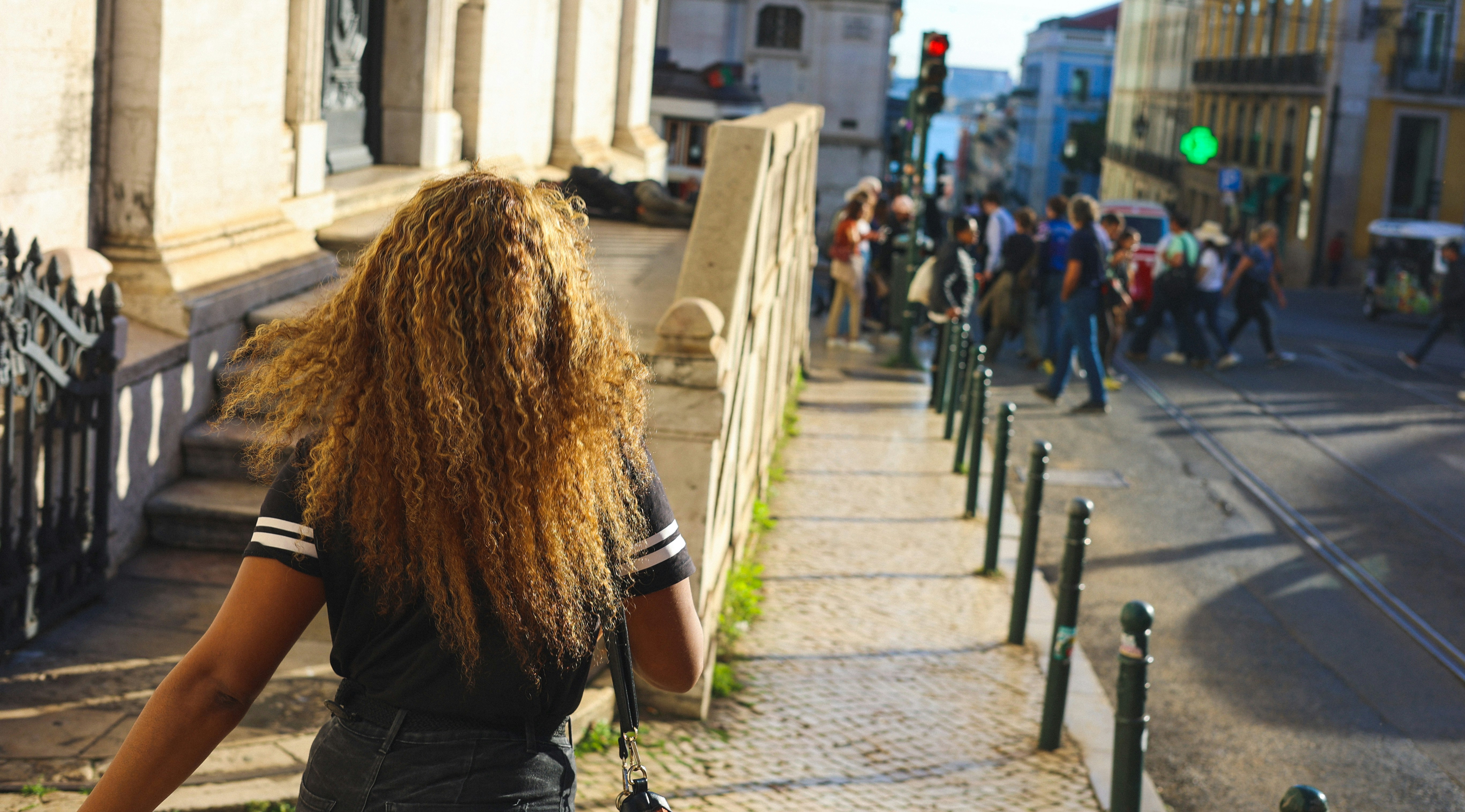 a woman with long hair walking down a street