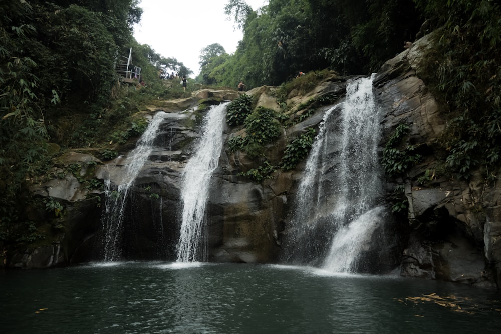 a group of people standing at the top of a waterfall