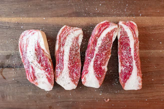 Close-up of fresh, marbled beef fillet slices arranged on a rustic wooden board.