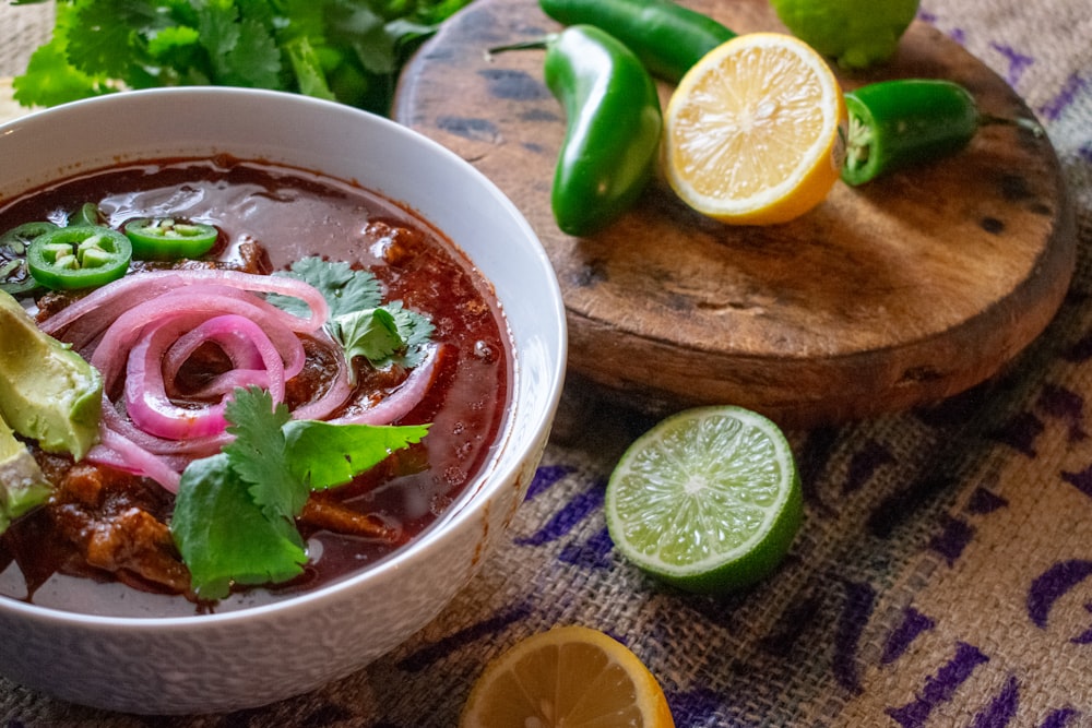 un bol de soupe au chili avec des limes et de la coriandre