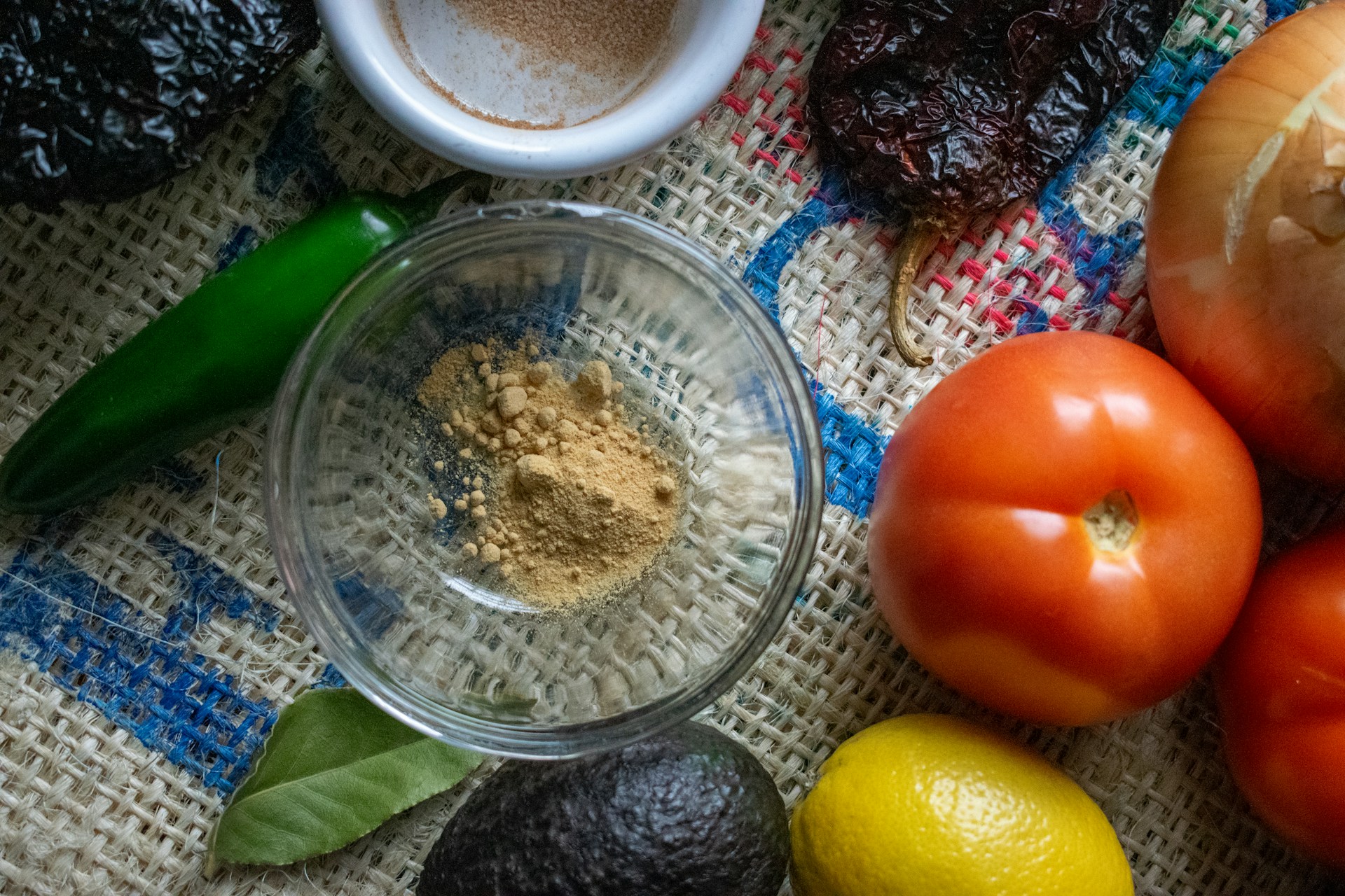 A close-up of traditional Oaxacan ingredients, including colorful chilies and fresh herbs, arranged artfully on a rustic wooden table.