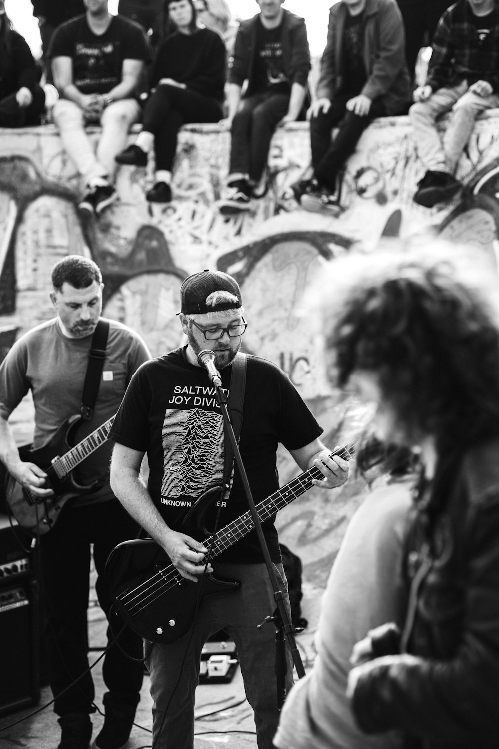 a group of young men playing guitars in front of a crowd