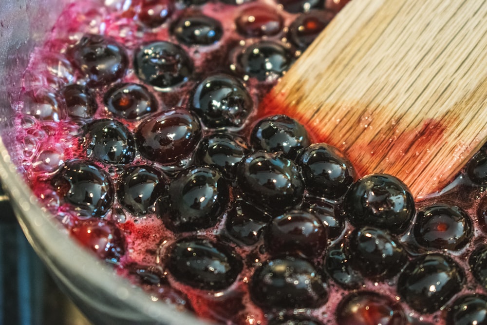 a wooden spoon stirring a pot of blueberries