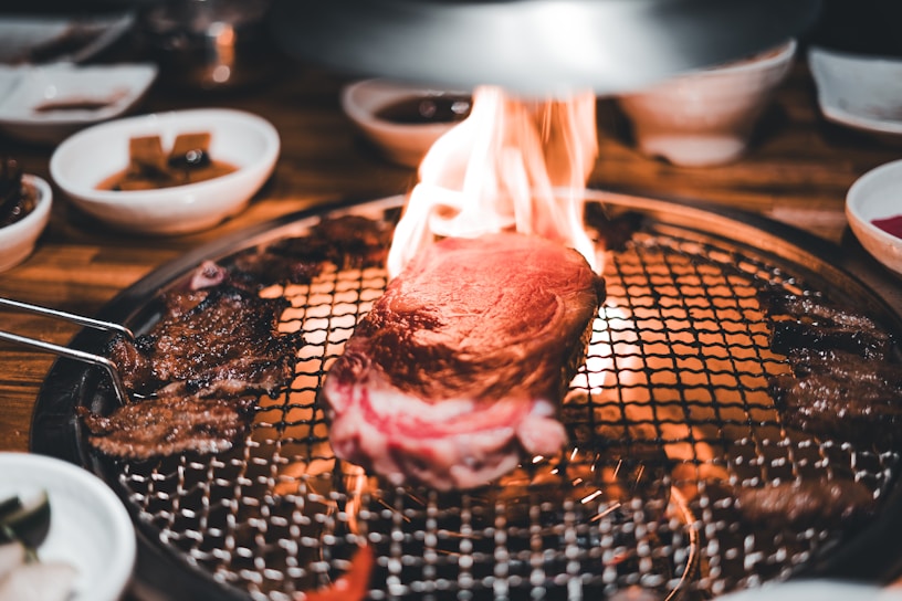 A sizzling grill with various meats cooking over open flames, showcasing the restaurant's specialty.