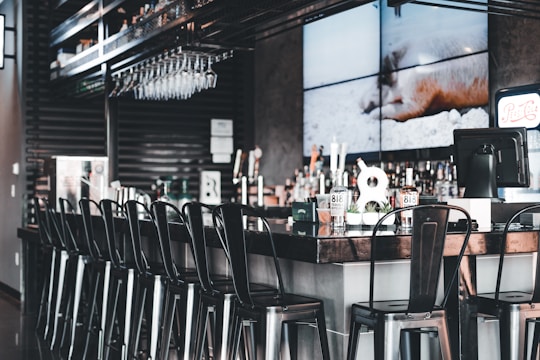 A busy bar counter with a sleek touchscreen POS system in use.