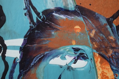 Abstract oil painting with bold splashes of blue and gold creating dynamic movement.