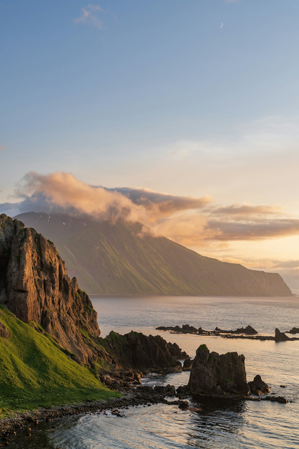 a grassy hill next to a body of water